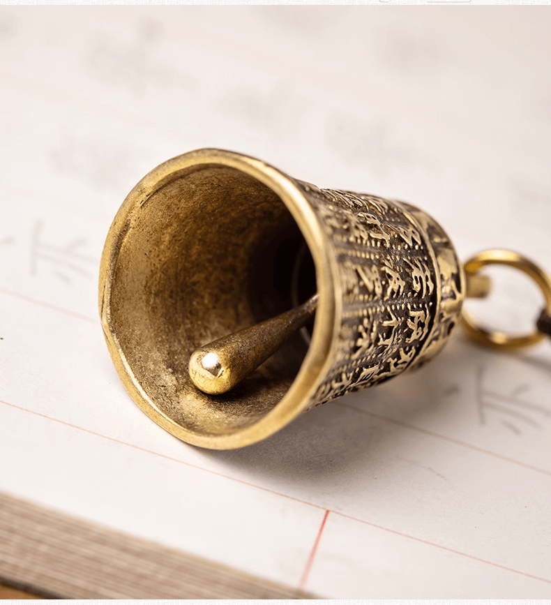 Detail of a brass bell from the PRAJNA PARAMITA SUTRA Buddha Clock wind chimes Pendant showing intricate designs.