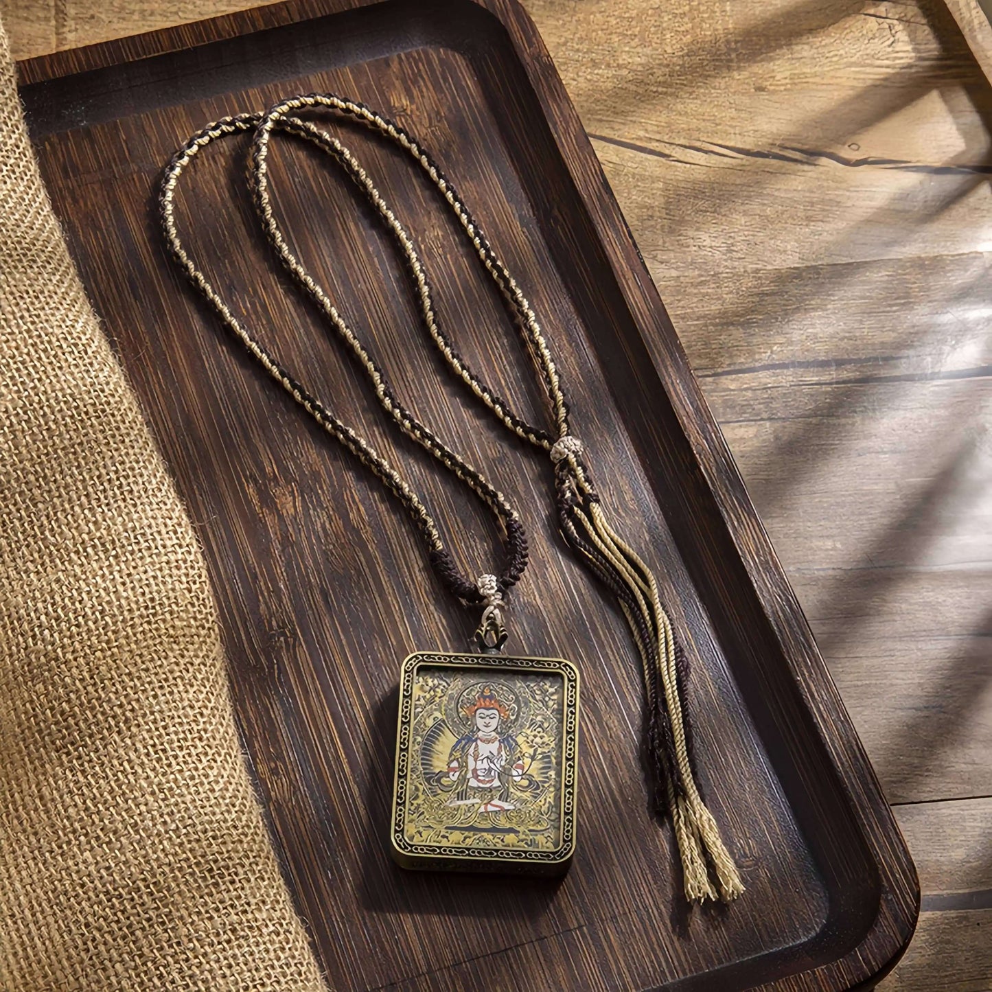 Tibetan Thangka Eight Protector Deities Pendant on a wooden tray, showcasing intricate design and craftsmanship.