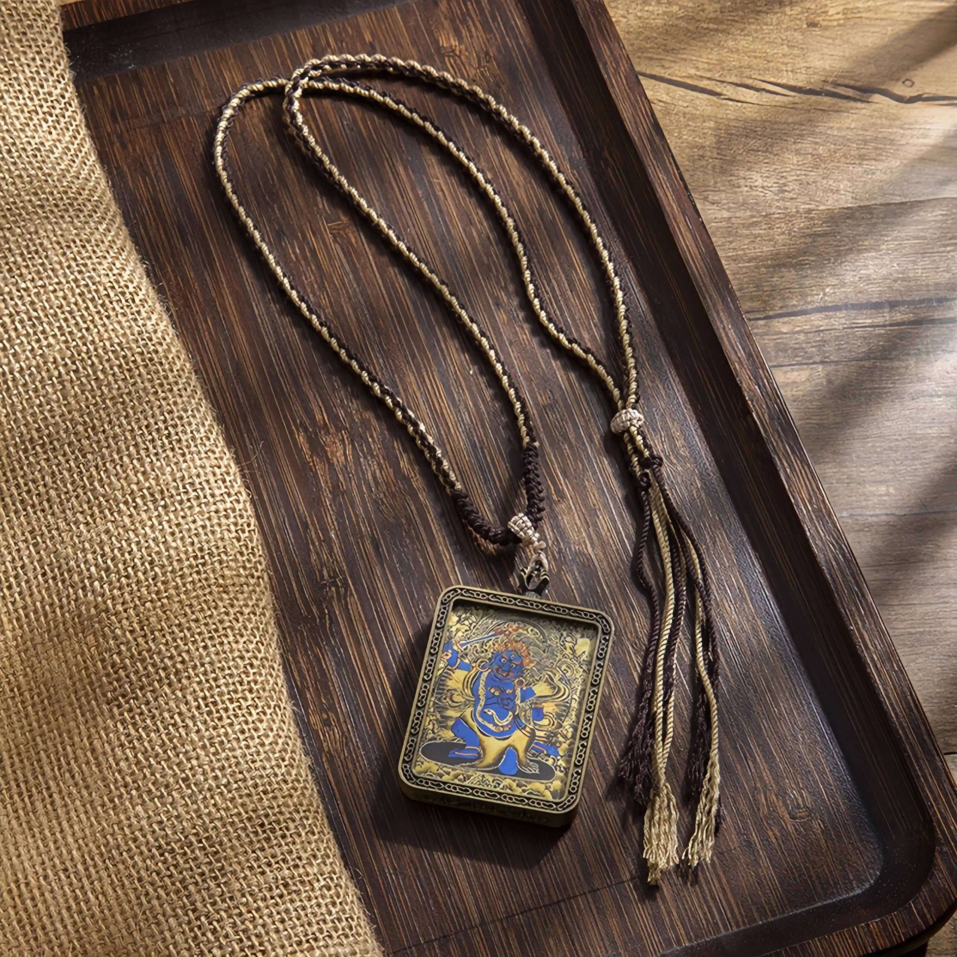 Tibetan Thangka Eight Protector Deities Pendant displayed on wooden tray, featuring vibrant scroll painting design.